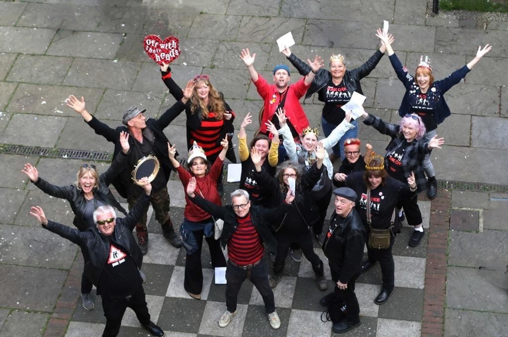 Group of approx 30 people waving and looking up 